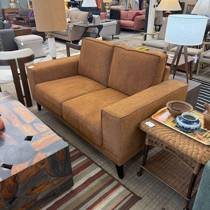 Brown sofa in a furniture store with various other items around