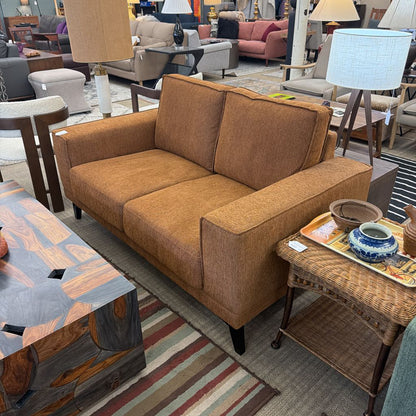 Brown sofa in a furniture store with various other furniture items around