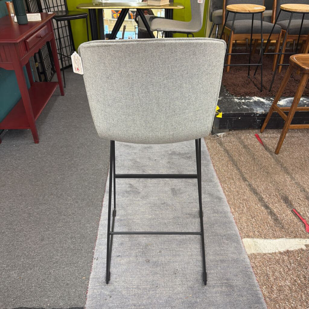 Gray bar stool in a room with tables and chairs