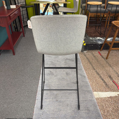 Gray bar stool in a room with tables and chairs