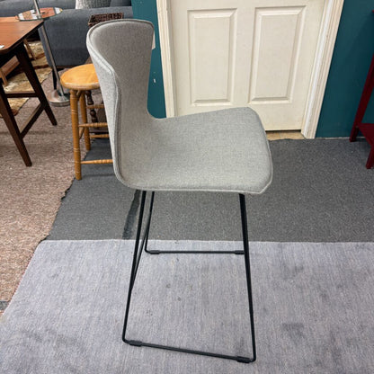 Gray chair with black legs on a gray carpeted floor