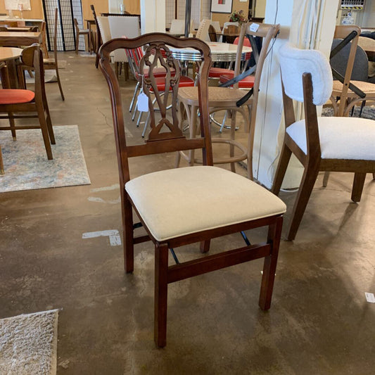 Wooden chair with a beige cushion in a showroom setting