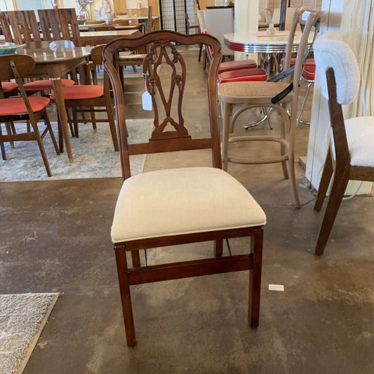 Wooden chair with a beige cushion in a furniture store setting