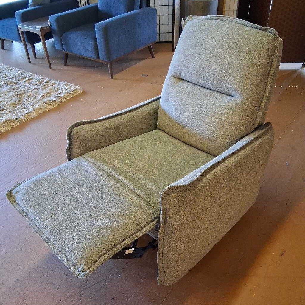 Beige recliner chair in a room with blue chairs and a rug.