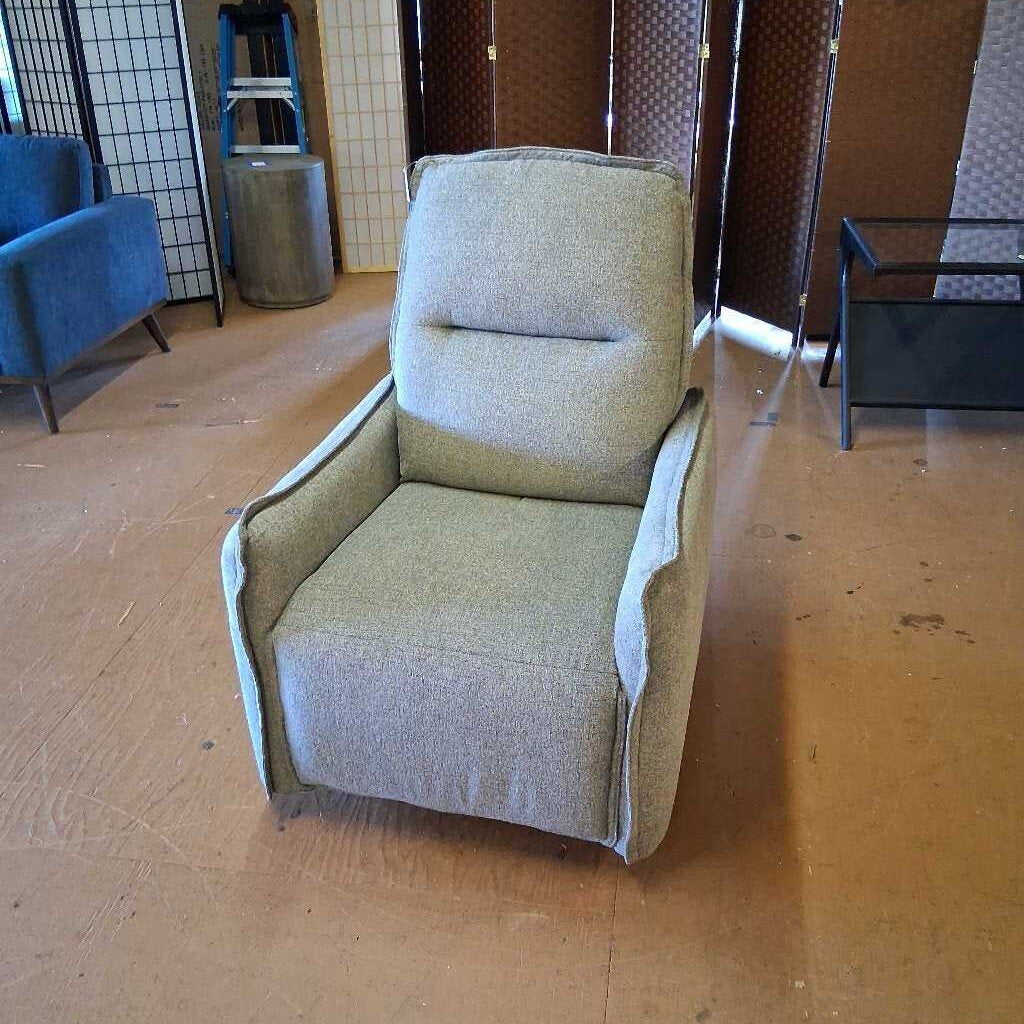 Gray armchair in a room with wooden floor and other furniture.