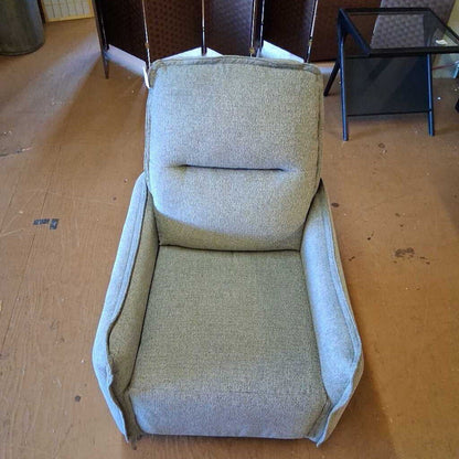 Gray upholstered chair on a wooden floor with furniture in the background