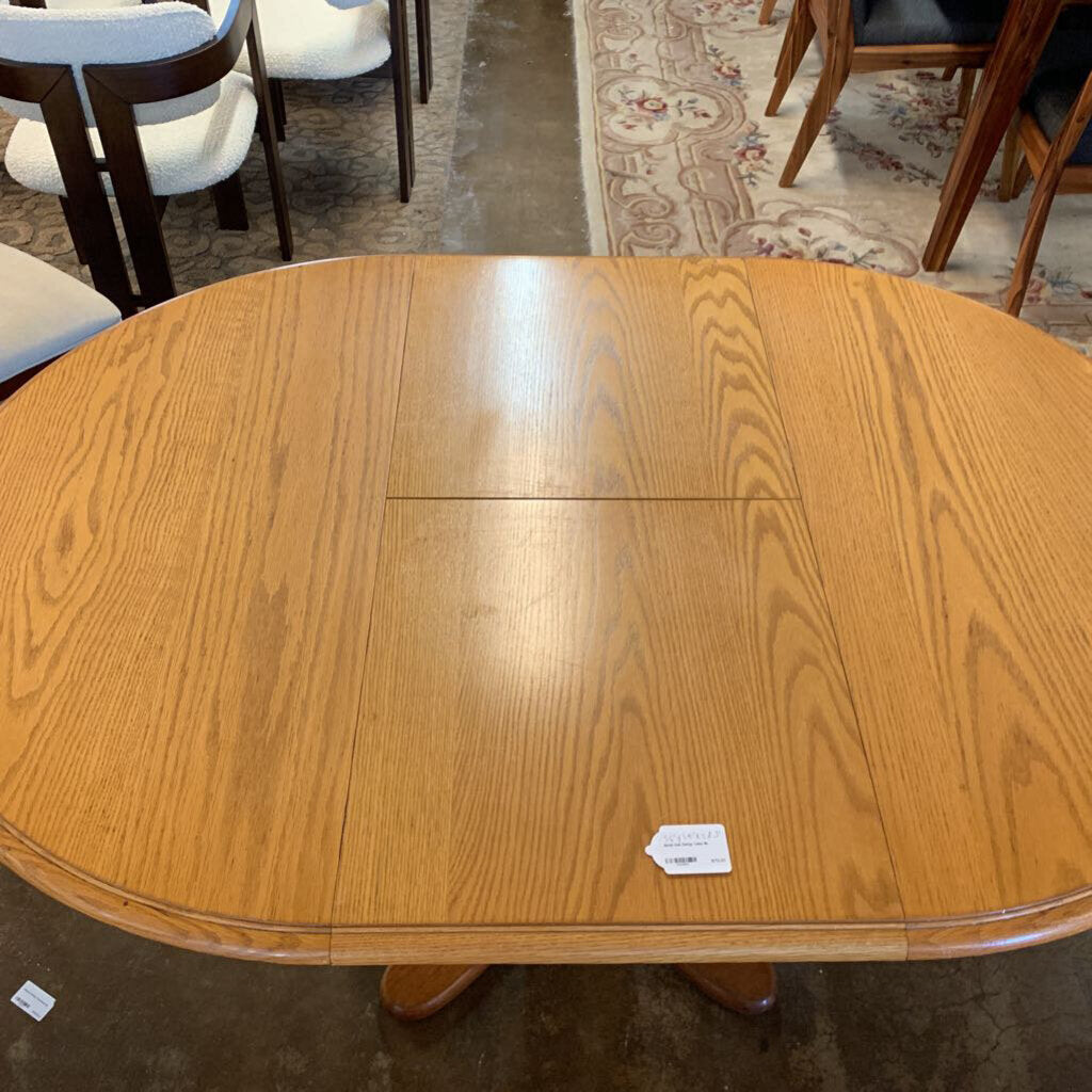 Wooden dining table with a tag on a carpeted floor