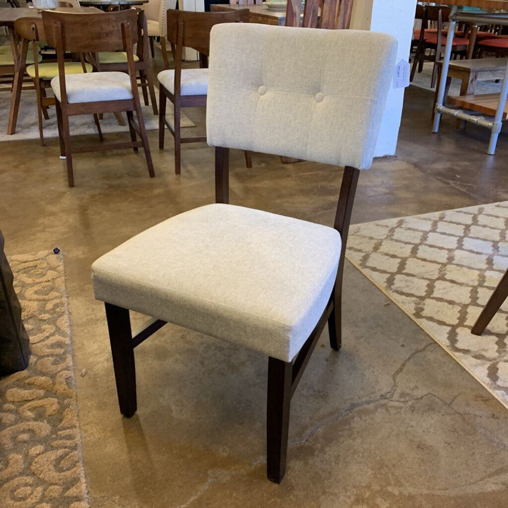 Chair with beige cushioned seat and backrest in a showroom setting
