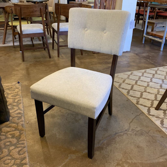 Chair with beige cushioned seat and backrest in a showroom setting