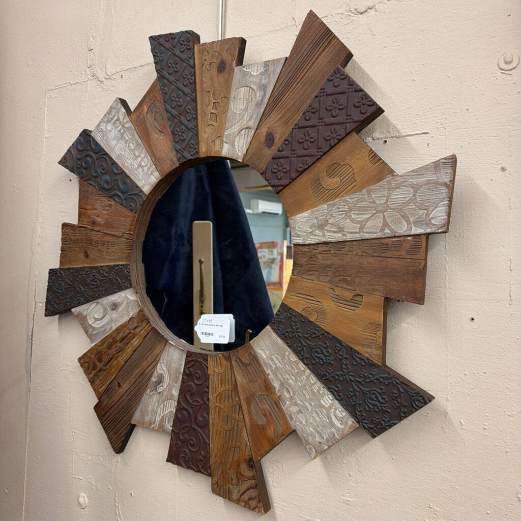 Decorative wall mirror with wooden and metal slats on a textured wall