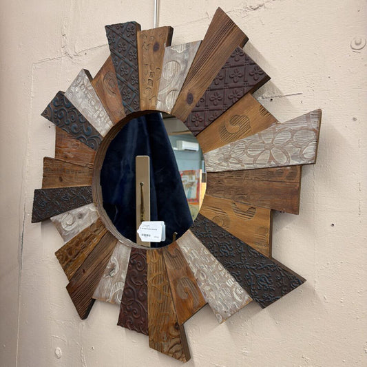 Decorative wall mirror with wooden and metal slats on a textured wall