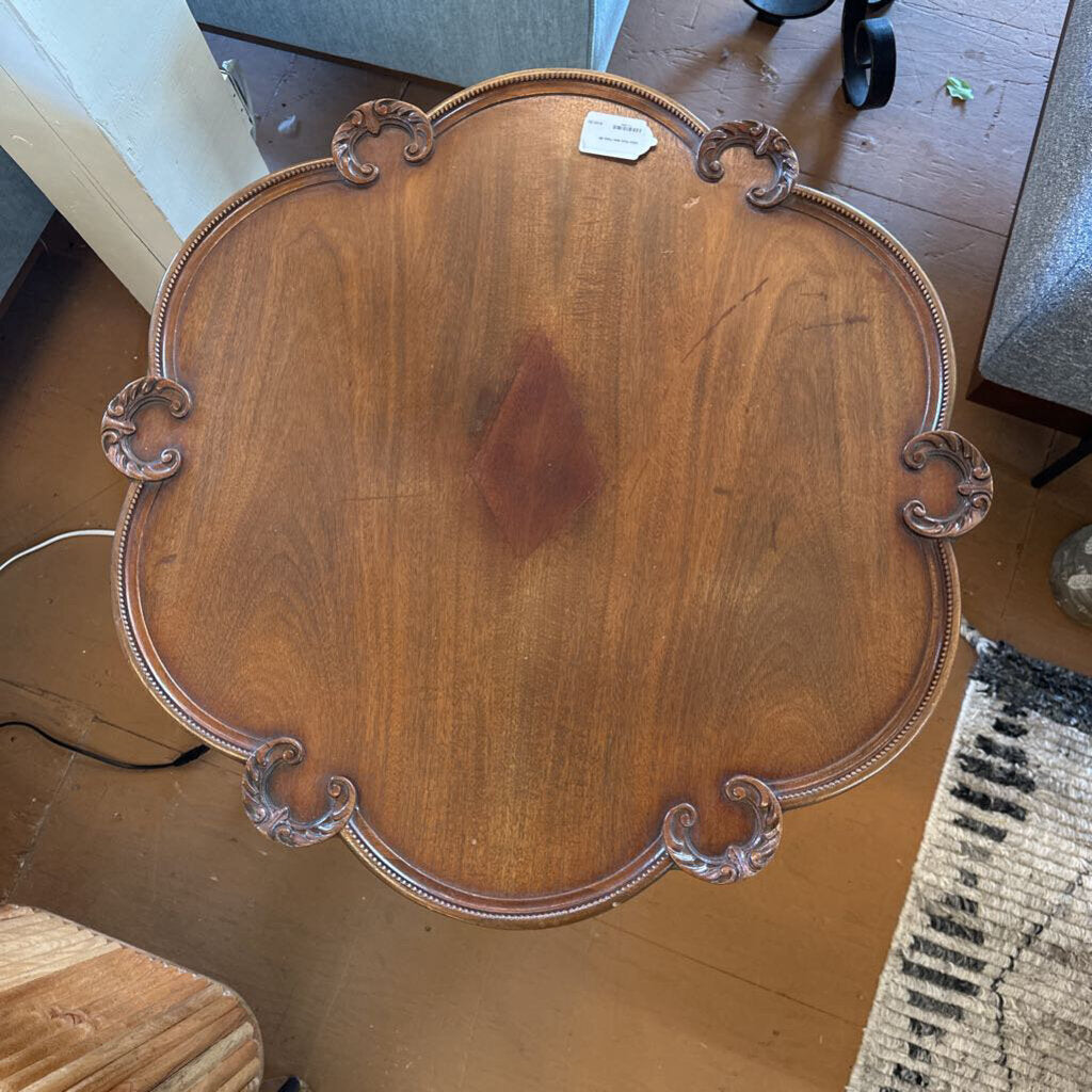 Wooden tray with decorative handles on a wooden floor
