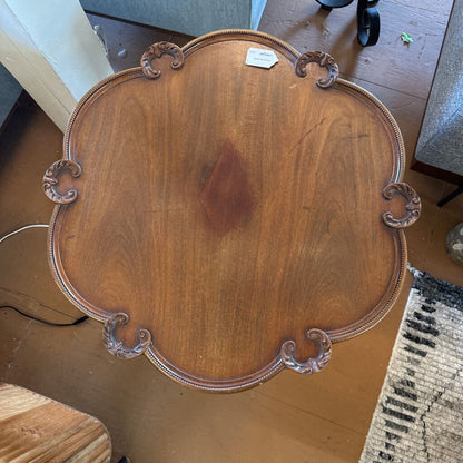Wooden tray with decorative handles on a wooden floor