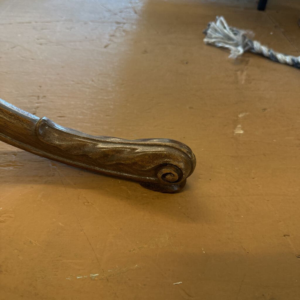 Decorative metal handle on a wooden surface
