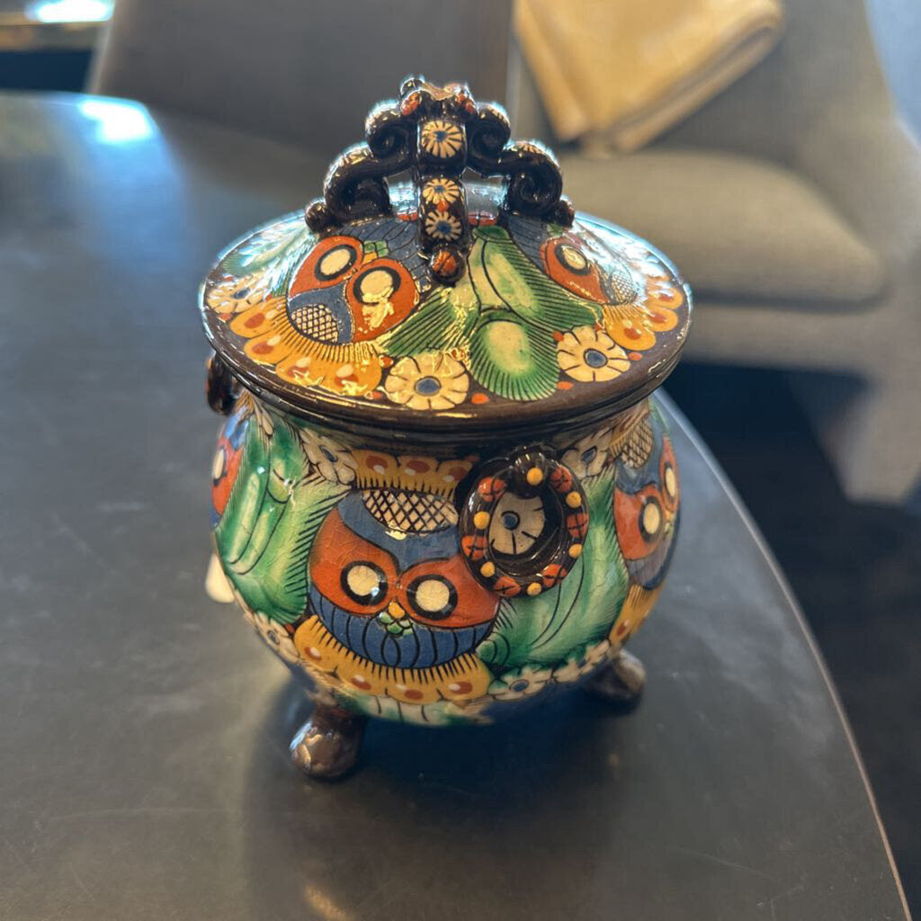 Colorful decorative jar with intricate designs on a dark surface