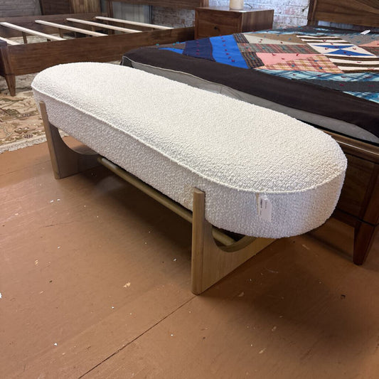 White mattress on a wooden bed frame in a room with other furniture.