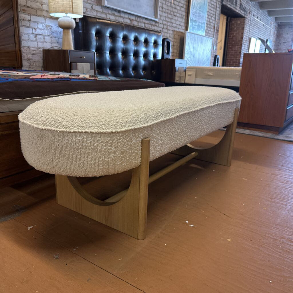 Oval-shaped ottoman with textured surface in a bedroom setting