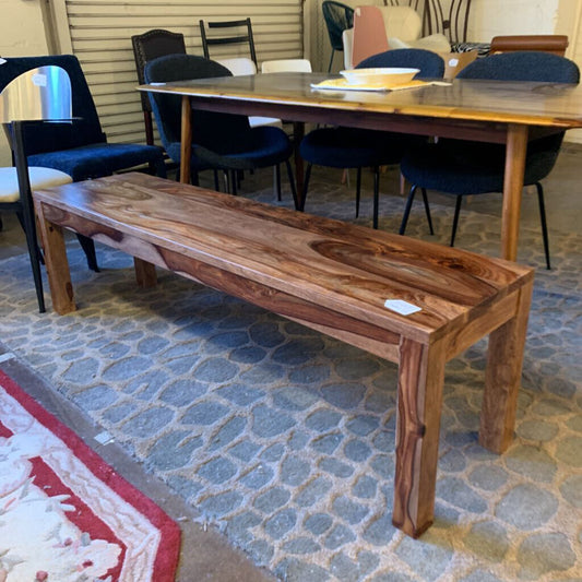 Wooden bench in a room with chairs and a table