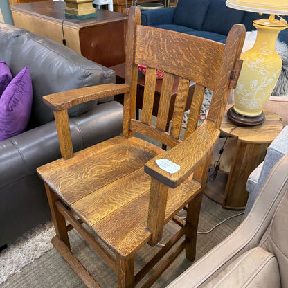 Wooden chair in a living room setting with furniture and decor.