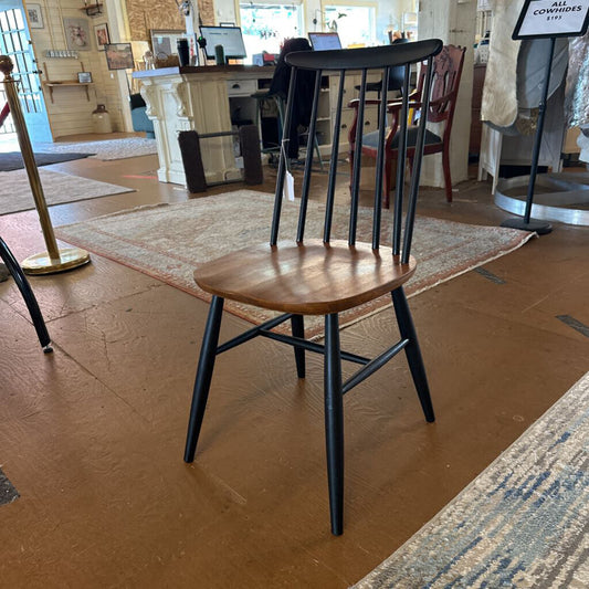 Wooden chair with black legs in a showroom setting