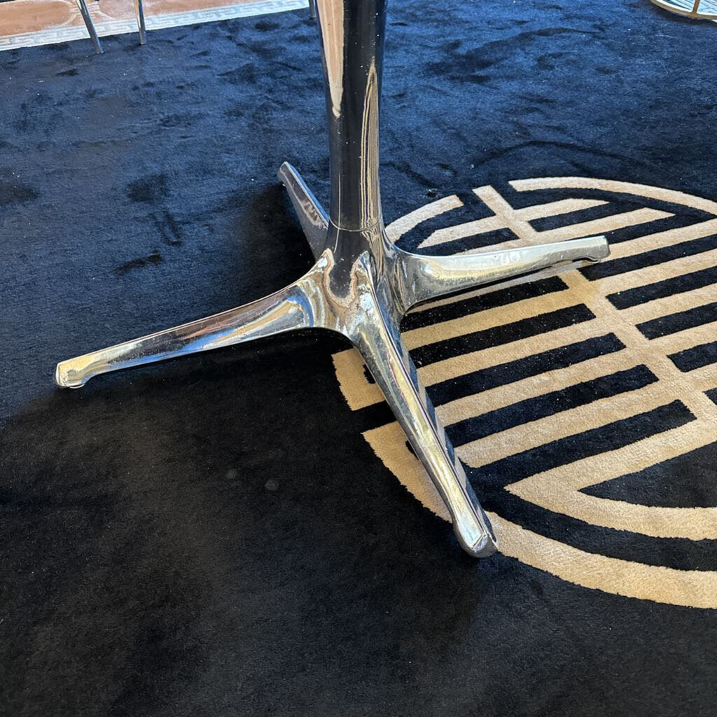 Metallic stand on a black and gold patterned rug