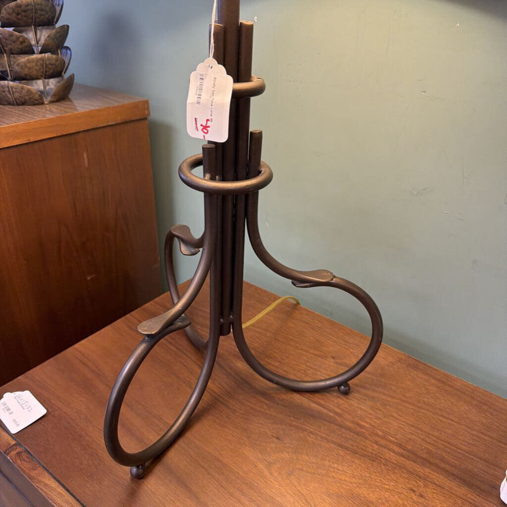 Decorative metal stand on a wooden surface with a tag in the background