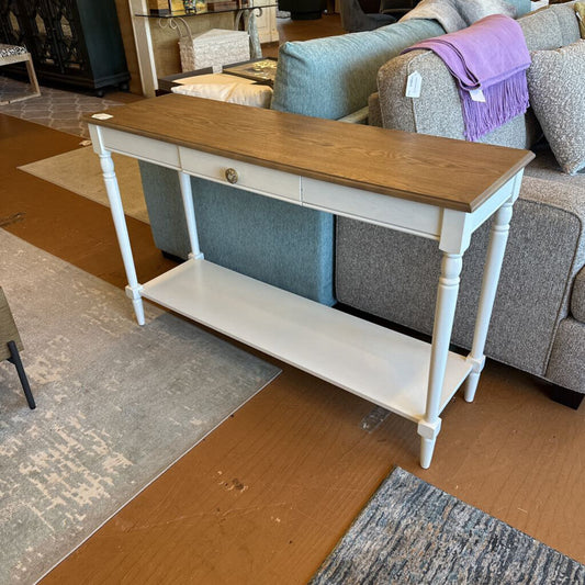 Wooden console table with white base in a furniture store setting