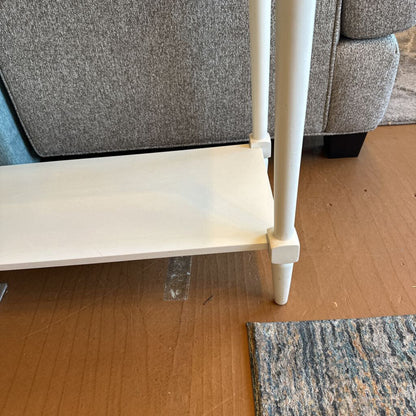 White metal shelf against a gray textured wall