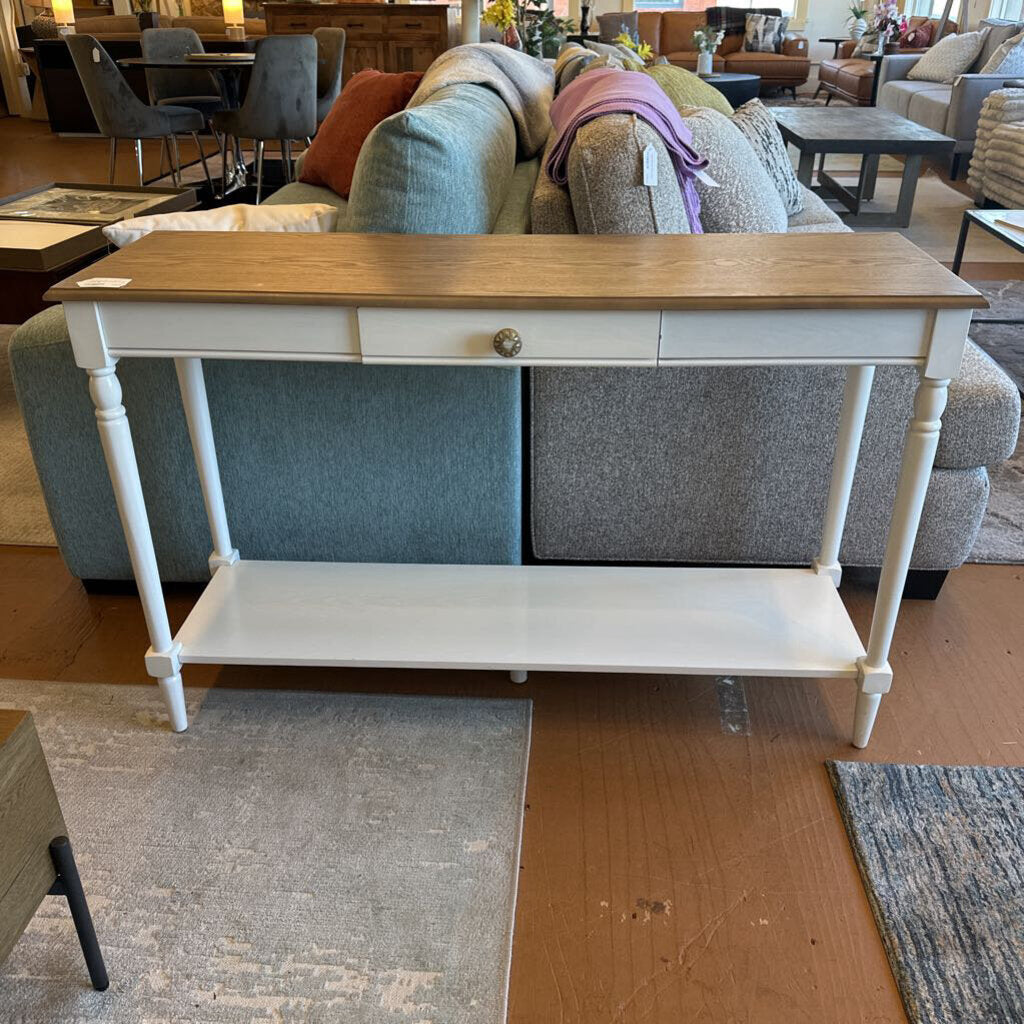 Console table with wooden top and white base in a furniture store setting