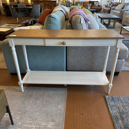 Console table with wooden top and white base in a furniture store setting
