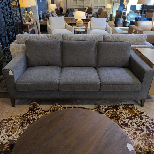 Gray sofa in a showroom with furniture and decor in the background