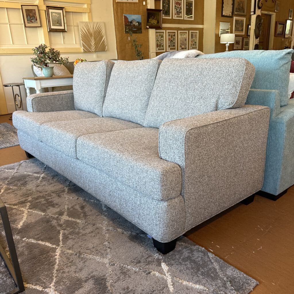 Gray sofa in a room with decorative elements and furniture.
