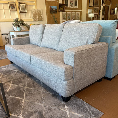 Gray sofa in a room with decorative elements and furniture.