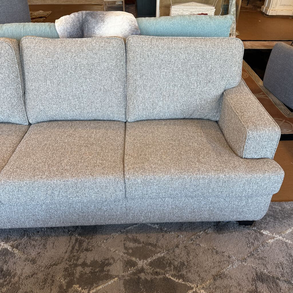 Gray and beige sofa in a room with a patterned rug