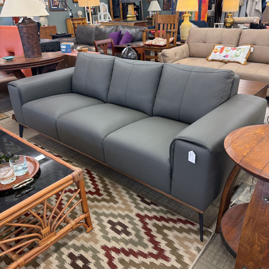 Gray sofa in a furniture store with various other items in the background