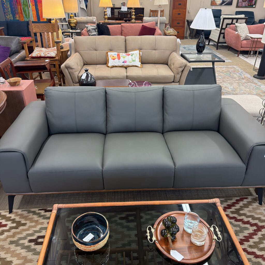 Gray sectional sofa in a room with furniture and decor