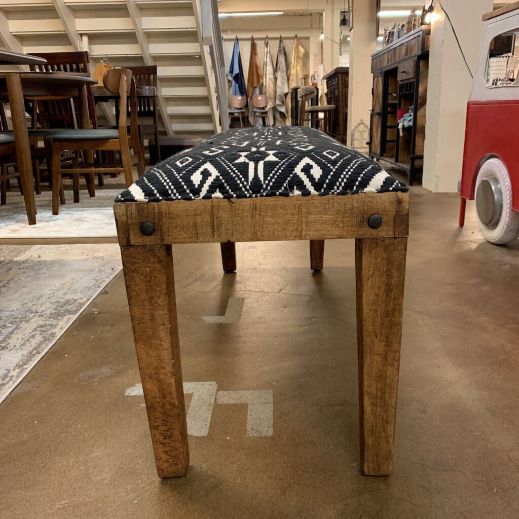 Wooden bench with patterned cushion in a store setting