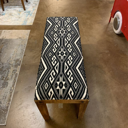 Chair with black and white patterned seat cover on a concrete floor.