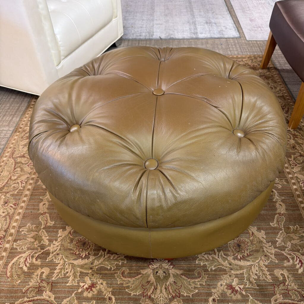 Round brown leather ottoman on a patterned rug