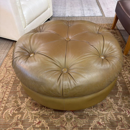 Round brown leather ottoman on a patterned rug