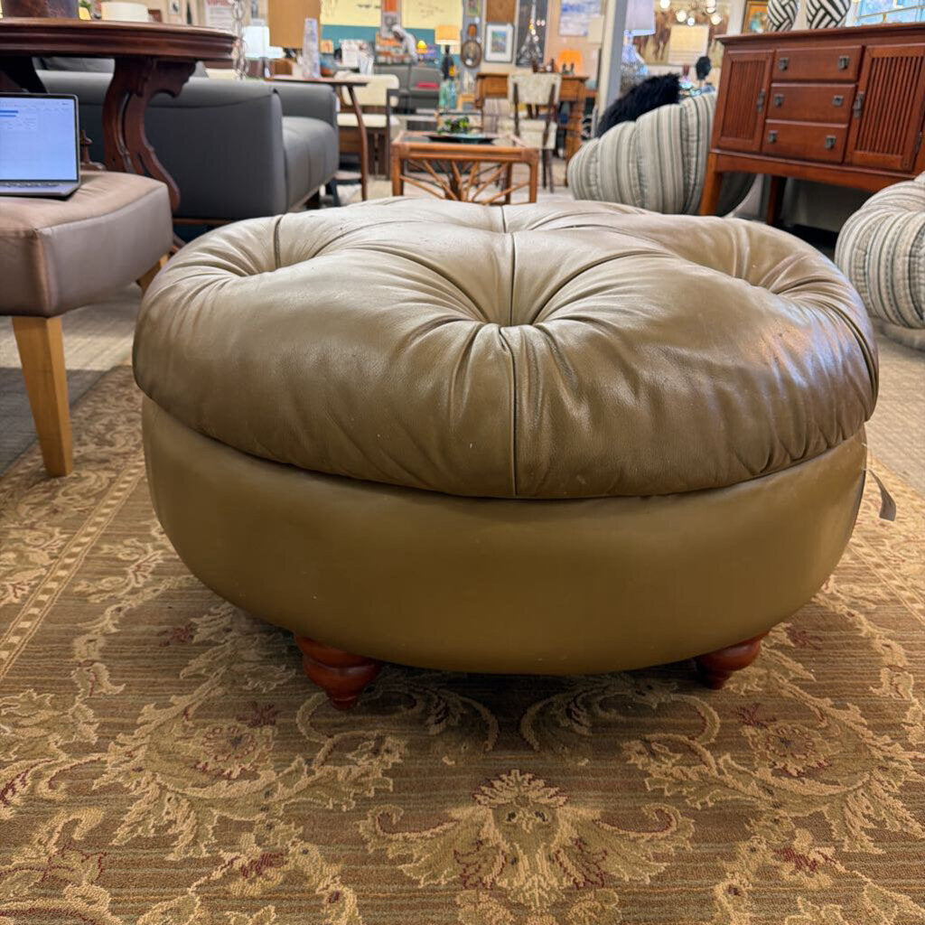 Round beige ottoman in a furniture store setting