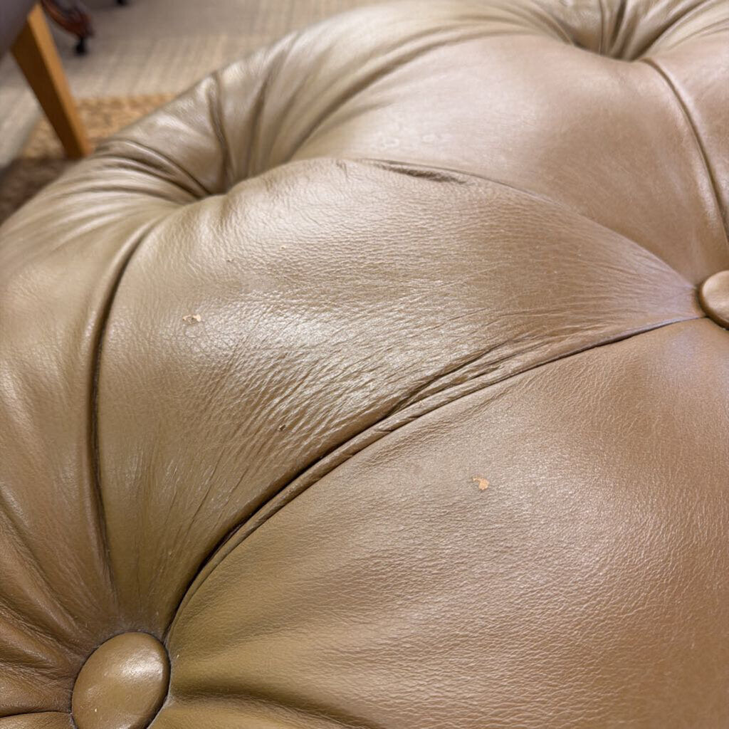 Close-up of a beige leather cushion with tufted design