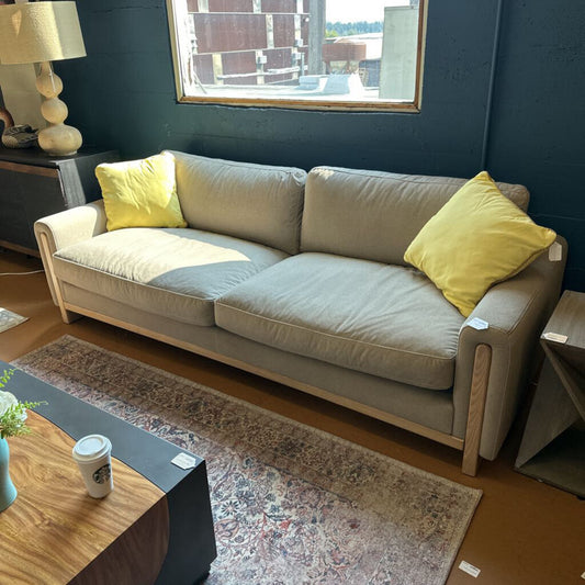 Beige sofa with yellow cushions in a living room setting
