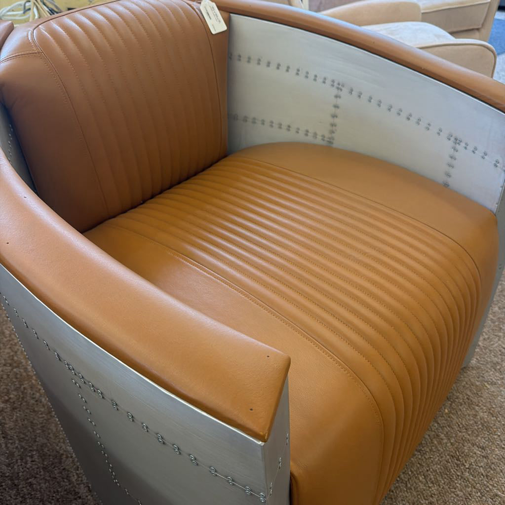 Brown leather chair with white frame in a showroom setting