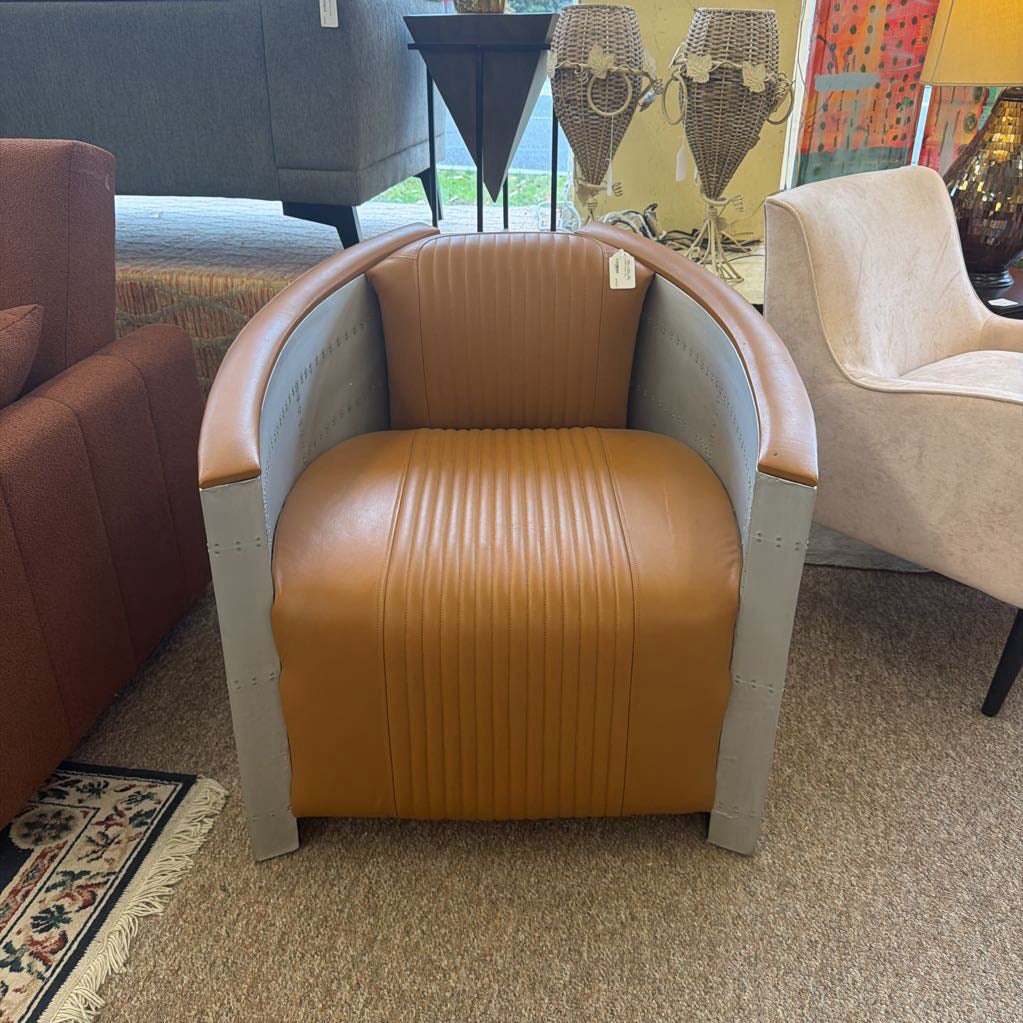 Brown armchair with ribbed texture in a room with other furniture.
