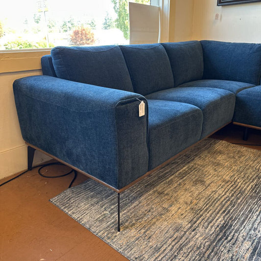 Blue sofa in a room with a window and rug