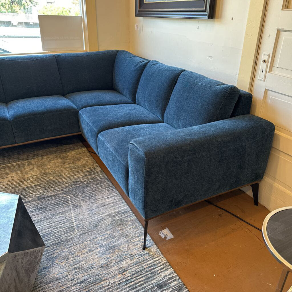 Blue sectional sofa in a room with a rug and table