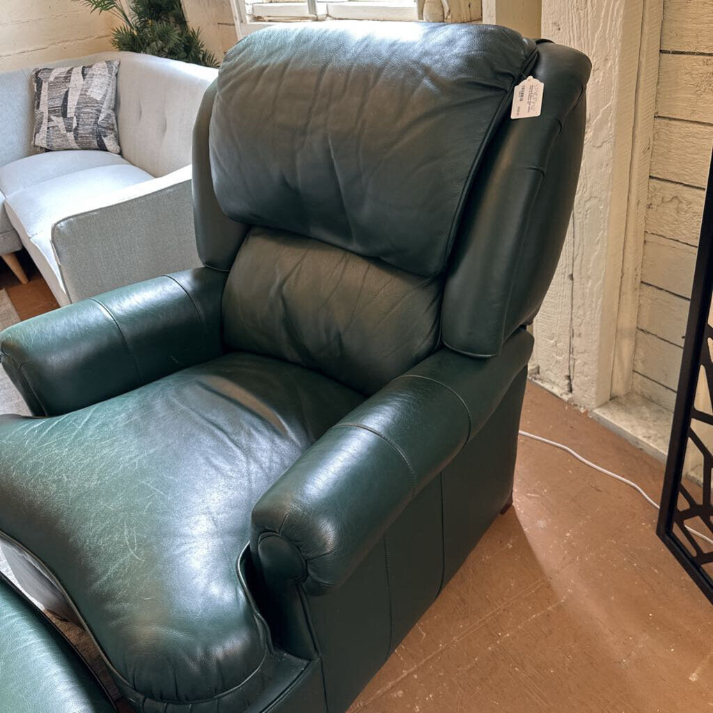Green leather recliner chair in a room with a white couch and decorative pillows.
