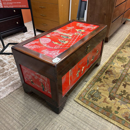 Wooden chest with red decorative top in a room setting