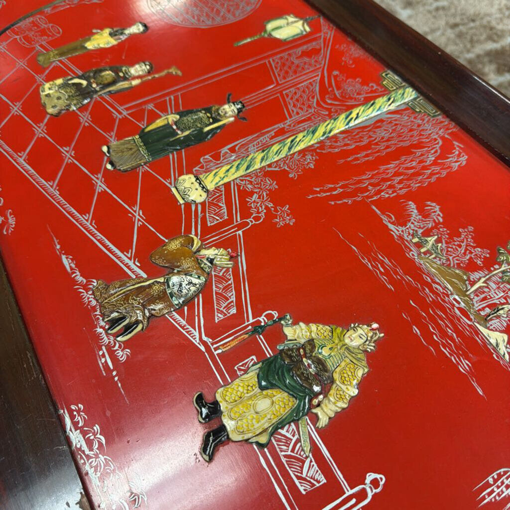 Decorative red surface with gold and green figurines on a wooden tray